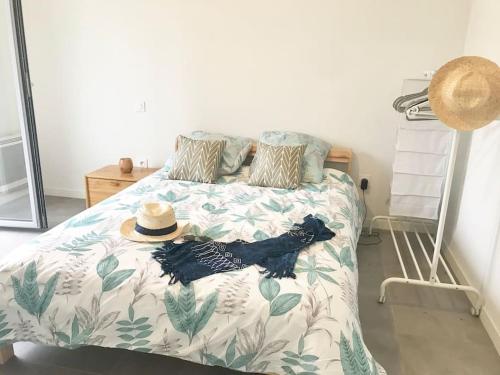 un chien noir allongé sur un lit avec un chapeau dessus dans l'établissement Bide Ona - Centre - Terrasse - Parking, à Bayonne