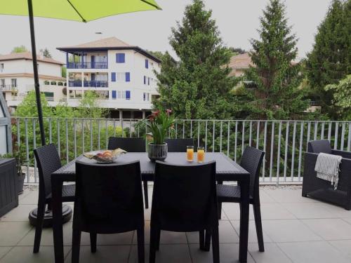 een tafel en stoelen op een balkon met een parasol bij T3 contemporain, plein centre, terrasse et parking in Bayonne