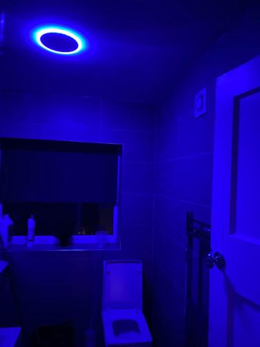 niebieski pokój z toaletą i niebieskim światłem w obiekcie Sapphire Suites Stunning 2-Bed House in Bradford w mieście Bradford