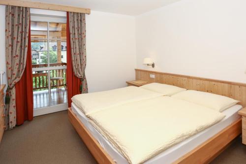 1 dormitorio con 1 cama y balcón en Waldthalerhof, en Monticolo
