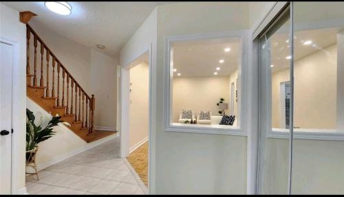 a hallway of a home with a window and stairs at Super Huge Comfortable King Bedroom near Toronto Pearson Airport in Mississauga