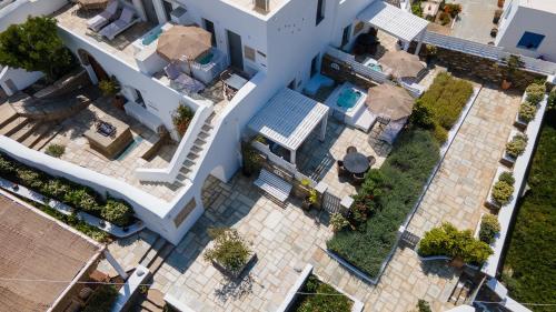 Cette chambre offre une vue sur un bâtiment blanc doté d'une piscine. dans l'établissement Ursa Major Suites, à Tinos