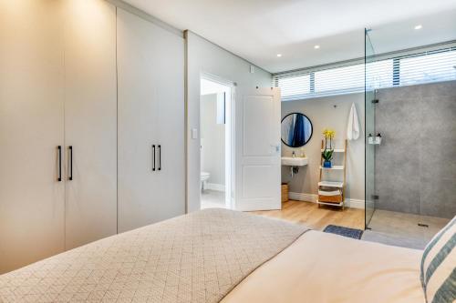 a bedroom with a large bed and a bathroom at Stonehurst Views - 1 Bed Flatlet in Cape Town