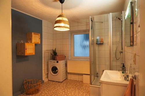 ein Badezimmer mit einem Waschbecken und einer Waschmaschine in der Unterkunft Up'n Swutsch im Norden am Meer in Bremerhaven
