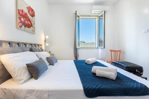 a bedroom with a large white bed with a blue blanket at The aurora's home in SantʼAndrea