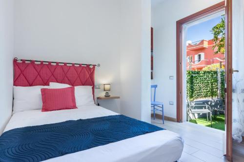 a bedroom with a large bed and a balcony at The aurora's home in Quartu SantʼElena