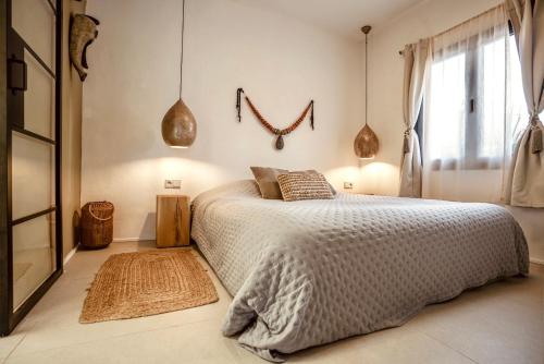 a bedroom with a large bed and a window at Can Yuca II in Cala Mondrago