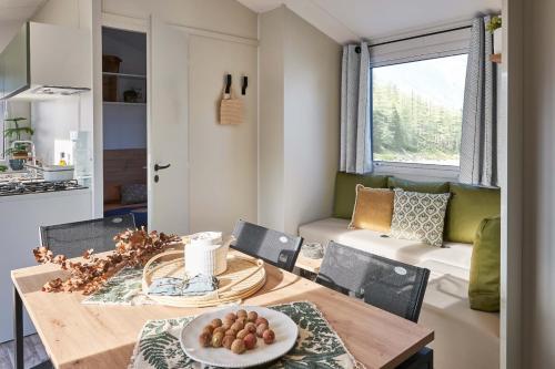 eine Küche und ein Wohnzimmer mit einem Holztisch und Stühlen in der Unterkunft Camping Park Er Lann in Saint-Pierre-Quiberon