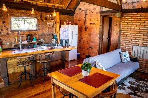 a kitchen and living room with a couch and a table at Caminho das Nuvens - Cabanas de Montanha in Bom Retiro
