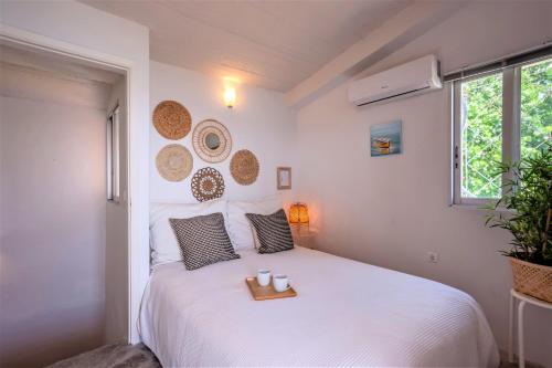 a bedroom with a white bed with a tray on it at Alterra Vita Captain's Cabin in Neos Marmaras