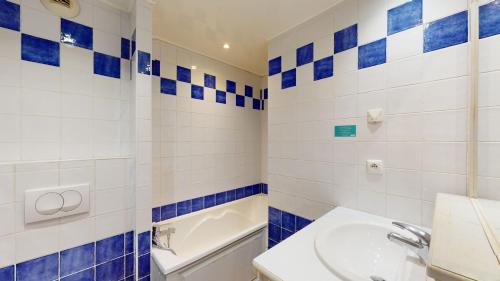 La salle de bains bleue et blanche est pourvue d'un lavabo et de toilettes. dans l'établissement Le Liouquet 117, à La Ciotat