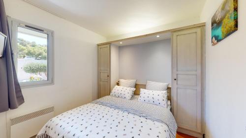 une petite chambre avec un lit et une fenêtre dans l'établissement Le Liouquet 117, à La Ciotat
