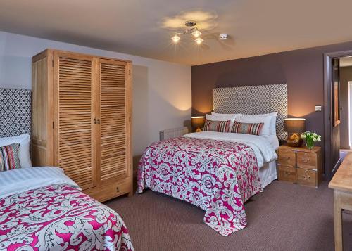 a bedroom with two beds with red and white sheets at The White Hart at Lydgate in Oldham