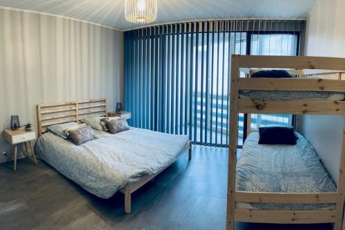 1 Schlafzimmer mit 2 Etagenbetten und einem großen Fenster in der Unterkunft Grand T2 renové, plein centre, 62 m² in Villard-de-Lans