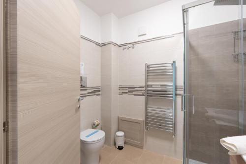 a bathroom with a toilet and a glass shower at Appartamento I Mori sea view in Balestrate