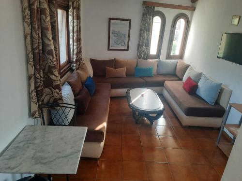 ein Wohnzimmer mit einem Sofa und einem Tisch in der Unterkunft Cosy Apartment à Kabila in Mʼdik