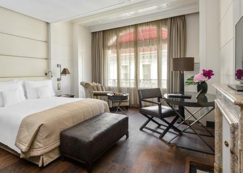 une chambre d'hôtel avec un lit, une table et des chaises dans l'établissement Lausanne Palace, à Lausanne