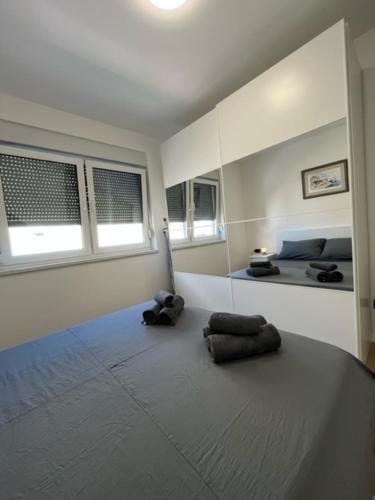 ein weißes Zimmer mit einem Bett und zwei Fenstern in der Unterkunft Noa in Kaštela
