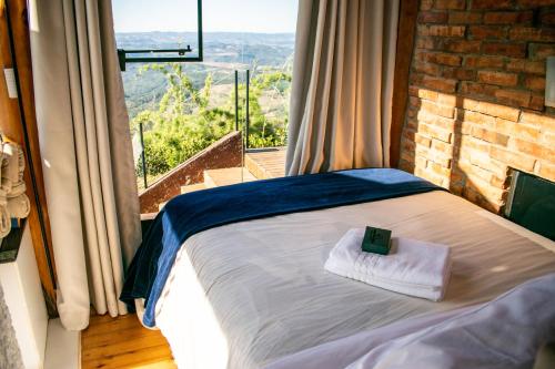 a bed in a room with a view of a window at Caminho das Nuvens - Cabanas de Montanha in Bom Retiro