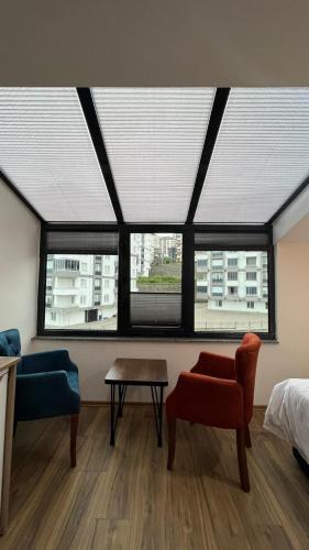 a room with windows and a bed and a table at Melissa Suite in Trabzon