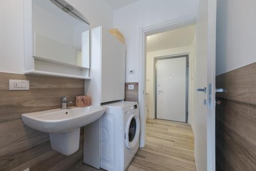 een badkamer met een wastafel en een wasmachine bij Arslan Family Apartment in Iseo