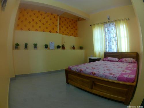 een slaapkamer met een bed en een raam bij Mountain View Homestay Kalimpong in Kalimpong