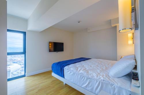 a bedroom with a bed and a tv on the wall at Batumi River Source in Batumi