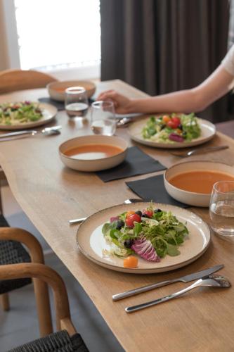 a wooden table with plates of food on it at MiHotel Sala in Lyon