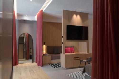 a living room with a couch and a flat screen tv at MiHotel Sala in Lyon