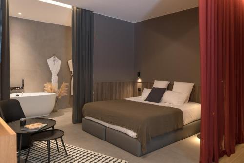 a bedroom with a bed and a bath tub next to a bathroom at MiHotel Sala in Lyon