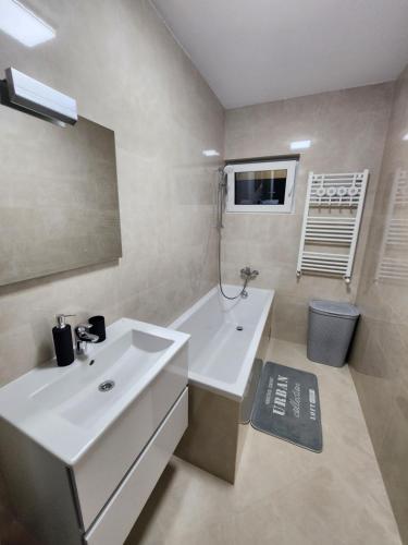 a bathroom with a white sink and a bath tub at DeLux Apartments with Terassa in Towers Ever Green in Iaşi