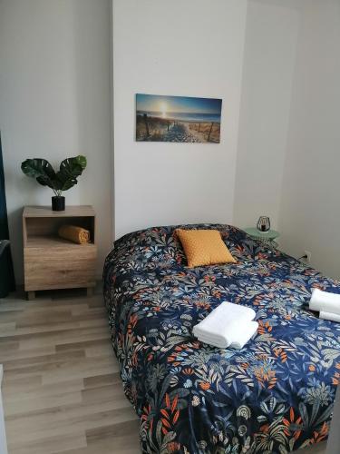 une chambre avec un lit et une plante en pot dans l'établissement La Vague Bleue, centre ville, à Tonneins