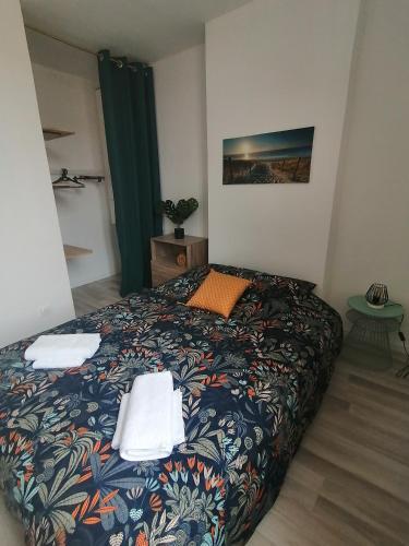 une chambre avec un lit avec des serviettes dessus dans l'établissement La Vague Bleue, centre ville, à Tonneins