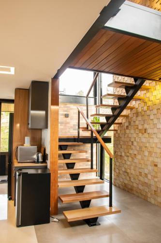 a staircase in a kitchen with a brick wall at Caminho das Nuvens - Cabanas de Montanha in Bom Retiro