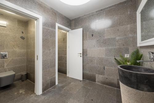 a bathroom with a stone wall with a sink at Luxury Villas Kabakum in Golden Sands