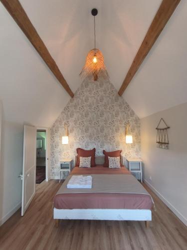 une chambre avec un grand lit dans un grenier dans l'établissement Gites Le Vieux Vinzelles, à Volvic