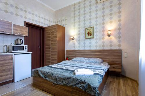 Dormitorio pequeño con cama y microondas en Malon Apartments, en Járkov