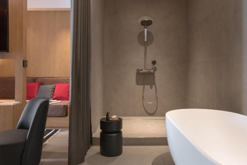 a bathroom with a shower with a toilet and a bed at MiHotel Sala in Lyon