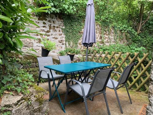 a blue table and chairs with an umbrella at L'Authentique maison de charme in Aubusson