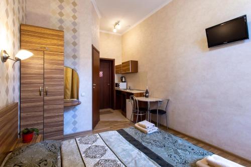 a room with a bed and a table and a television at Malon Apartments in Kharkiv