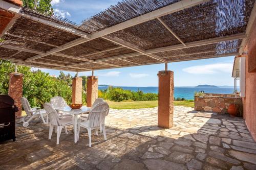 a patio with a table and chairs under a pergola at Alterra Vita Captain's Cabin in Neos Marmaras
