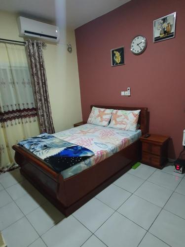 a bedroom with a bed and a clock on the wall at Appartement Cosy & Chill in Douala