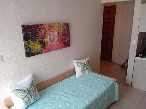 a bedroom with two beds and a painting on the wall at Popi' s apartment 50 metres from the sea! in Sozopoli