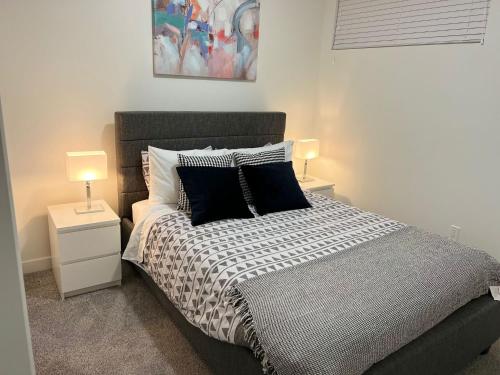 una camera con un letto con due comodini e due lampade di Beautiful 2 bedroom home away from home a Calgary