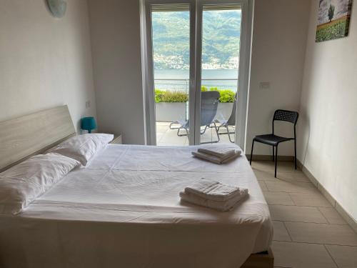 Residence Il Poggio في Dorio: غرفة نوم عليها سرير وفوط
