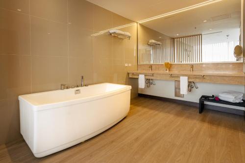 a bathroom with a large tub and a large mirror at Liv Hotels in Bogotá