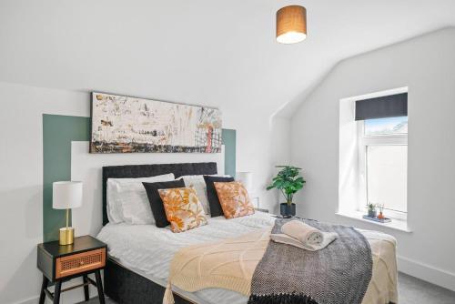 a white bedroom with a bed with orange pillows at Fabulous and Stylish House in Nottingham in Mansfield