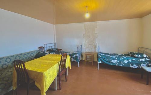 Habitación con mesa, sillas y cama en Tsatʼer Guest House, en Tsatʼer