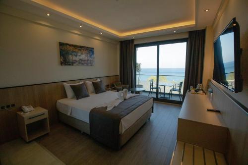 a hotel room with a bed and a large window at Polaris Otel & Beach Club in Mersin