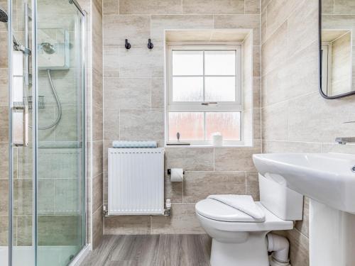 y baño con aseo, lavabo y ducha. en Modern Comfortable Home Pass The Keys en Chichester